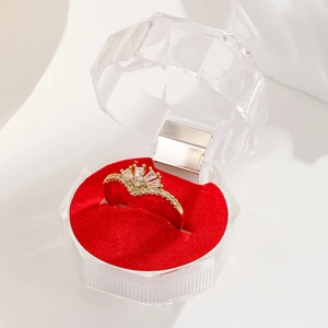 Close-up of a gold crown ring with zircons and pearls in a red velvet display box