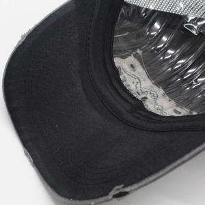 Detailed view of distressed baseball cap showing multi-row stitching and breathable mesh material