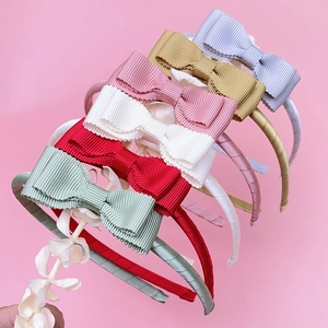 Close-up of colorful ribbed fabric headbands with layered bow details for young girls