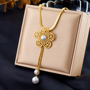 Elegant gold flower necklace with pearls and fringe on a jewelry box display