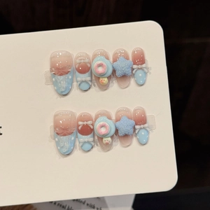 Faux ongles faits main dégradé rose et bleu avec étoiles 3D et breloques donuts