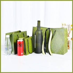 Three green Damask pattern luxury paper gift bags with black rope handles and ribbon