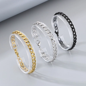 Dettaglio di bracciali a catena cubana oro, argento e nero con chiusure a moschettone
