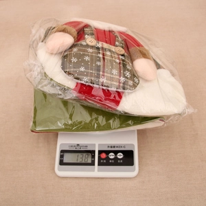 Detail showing an oversized Christmas stocking being weighed at 138 grams on a digital scale