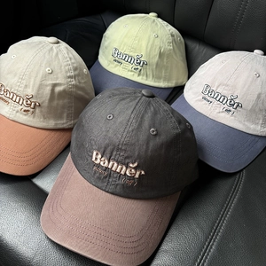 Close-up of baseball caps with embroidered letters and contrasting two-tone color panels