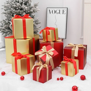 Red and gold Christmas gift box set with silk ribbons stacked in a festive display
