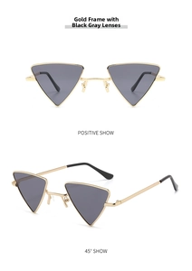 Detail of triangle sunglasses with gold metal frames and dark grey lenses for a punk look