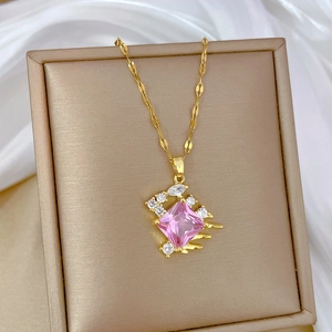 Detail of gold necklace featuring a pink square gemstone pendant with zircon halo