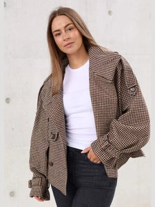 Close-up of brown houndstooth check pattern and button detail on short woolen jacket
