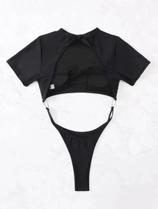 Flat lay of black one-piece swimsuit with cutout waist and silver ring accents