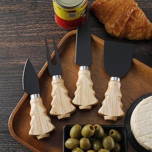 Close-up of 4-piece stainless steel cheese knife set with Christmas tree wood handles