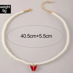 Detail of pearl necklace with red butterfly pendant and adjustable gold lobster clasp