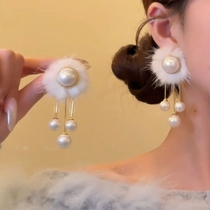 Boucles d'oreilles boules de fourrure blanche avec glands de perles et détails dorés
