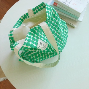 Detailed top view of a large cotton tote bag with green oval dot print and soft webbing handles