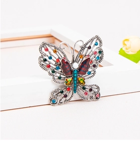 Close-up of colorful butterfly brooch with multi-color rhinestones and enamel wings