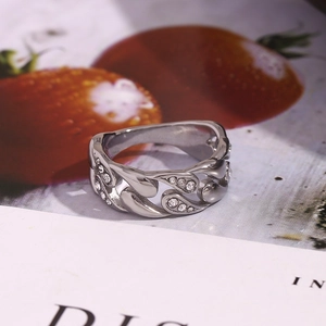 Macro shot of silver Cuban link ring with sparkling rhinestones on strawberry background