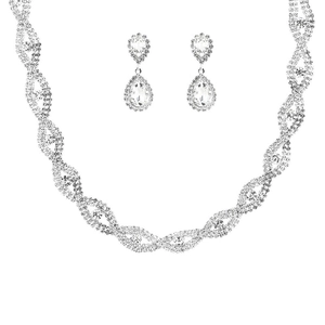 Close-up of sparkling silver bridal jewelry set with wavy necklace and teardrop earrings