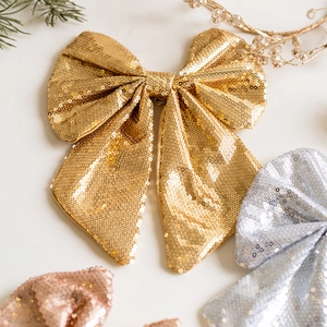 Set of sparkling sequined Christmas bows in gold, silver and pink for holiday tree decor