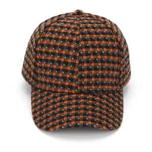 Close-up of the tweed texture on the orange and black plaid baseball cap
