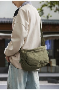 Close-up of military green nylon messenger bag with water-resistant fabric and wide strap