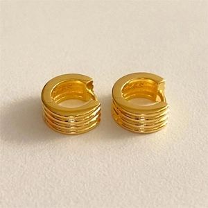 Detail of gold S925 sterling silver hoop earrings with textured ribbed design