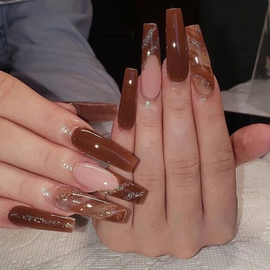 Brown marble press-on nails with gold glitter accents and long coffin shape design