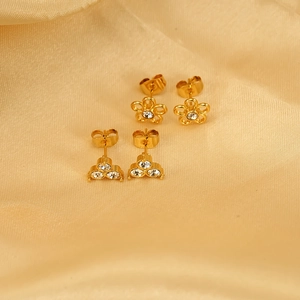Elegant gold stainless steel floral and zircon stud earrings on champagne silk fabric