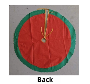 Detail view of red Christmas tree skirt with green scalloped edges and gold ribbon ties