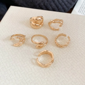 Detailed view of six gold rings featuring lava texture and irregular geometric designs