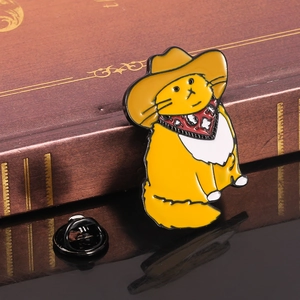 Cute yellow cowboy cat enamel pin with hat and red scarf on vintage book background