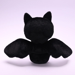 Rear view detail of soft black plush bat wings and fine texture on a stuffed doll toy