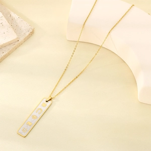 Detailed close-up of 18K gold plated rectangular pendant with embossed lucky symbols
