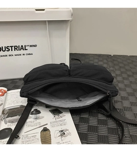 Detail view of black nylon messenger bag interior with gray lining and multiple compartments
