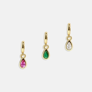 Detailed view of pear-cut pink, emerald and clear birthstone pendants in 18K gold plating