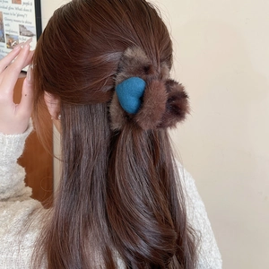 Vue détaillée d'une pince à cheveux en peluche marron avec décor de cœur bleu
