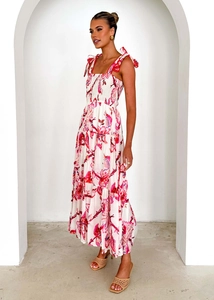 Detail of floral maxi dress showing smocked bodice and tied straps in red and pink