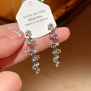 Gros plan détaillé de boucles d'oreilles S925 avec pampilles et breloques de fleurs