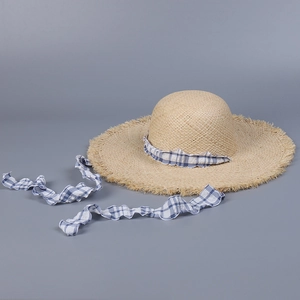 Detail of raffia sun hat with blue checkered ribbons and frayed edge brim detail