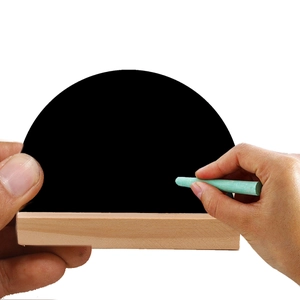 Detail view of small arched wooden blackboard with base held by hands for home decor