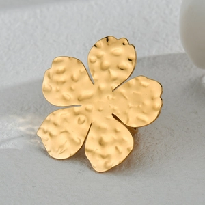 Macro shot of gold floral ring featuring unique hammered metal texture and minimalist style