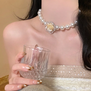 Elegant multi-layer pearl necklace with a rhinestone flower pendant worn by a model