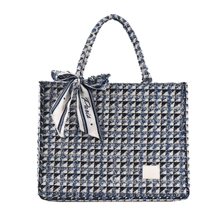 Blue houndstooth canvas tote bag with silk scarf decoration on white background