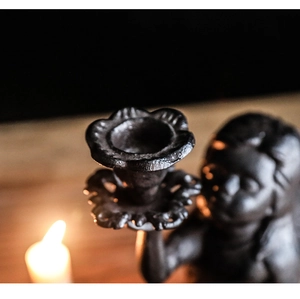 Macro detail of vintage cast iron candle holder featuring rustic metal texture and matte finish