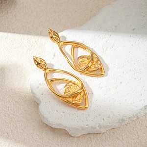 Elegant gold hollow irregular earrings with hammered texture on a white stone background