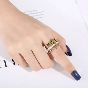 Close-up of gold layered roman numeral rings with inlaid diamonds on model finger