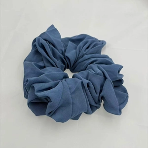 Detail shot of the soft blue chiffon fabric and elastic texture of the hair scrunchie