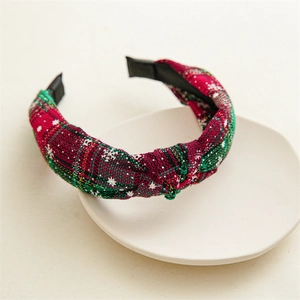 Detail of Christmas plaid wide headband with white stars and knot on ceramic plate