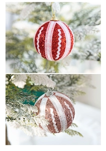 Nahaufnahme von 8cm rosa und roten Weihnachtskugeln mit Glitzer auf verschneiten Zweigen