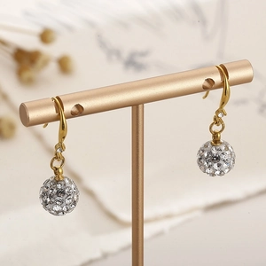 Gros plan détaillé de boucles d'oreilles dorées avec pendentifs sphériques en cristaux