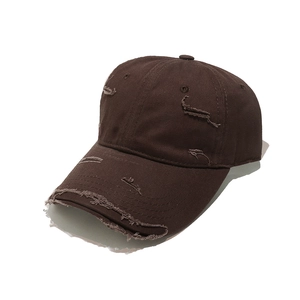 Close-up of distressed dark brown baseball cap with vintage ripped details and worn texture